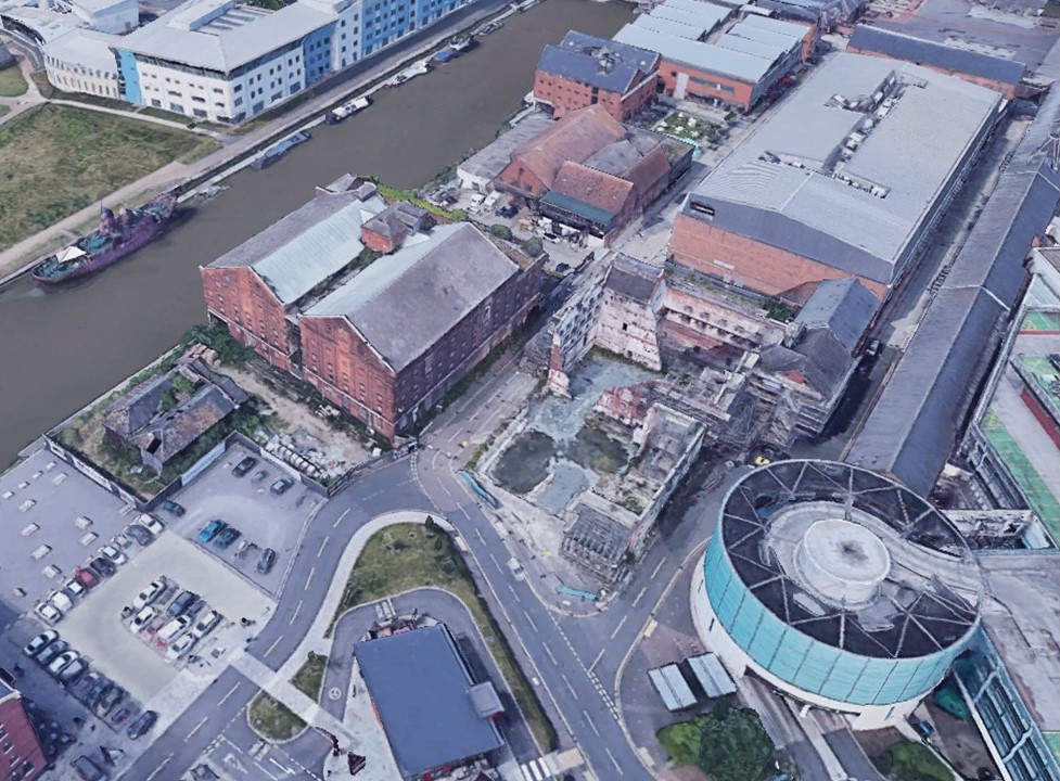 Aerial view of a river and buildingsDescription automatically generated